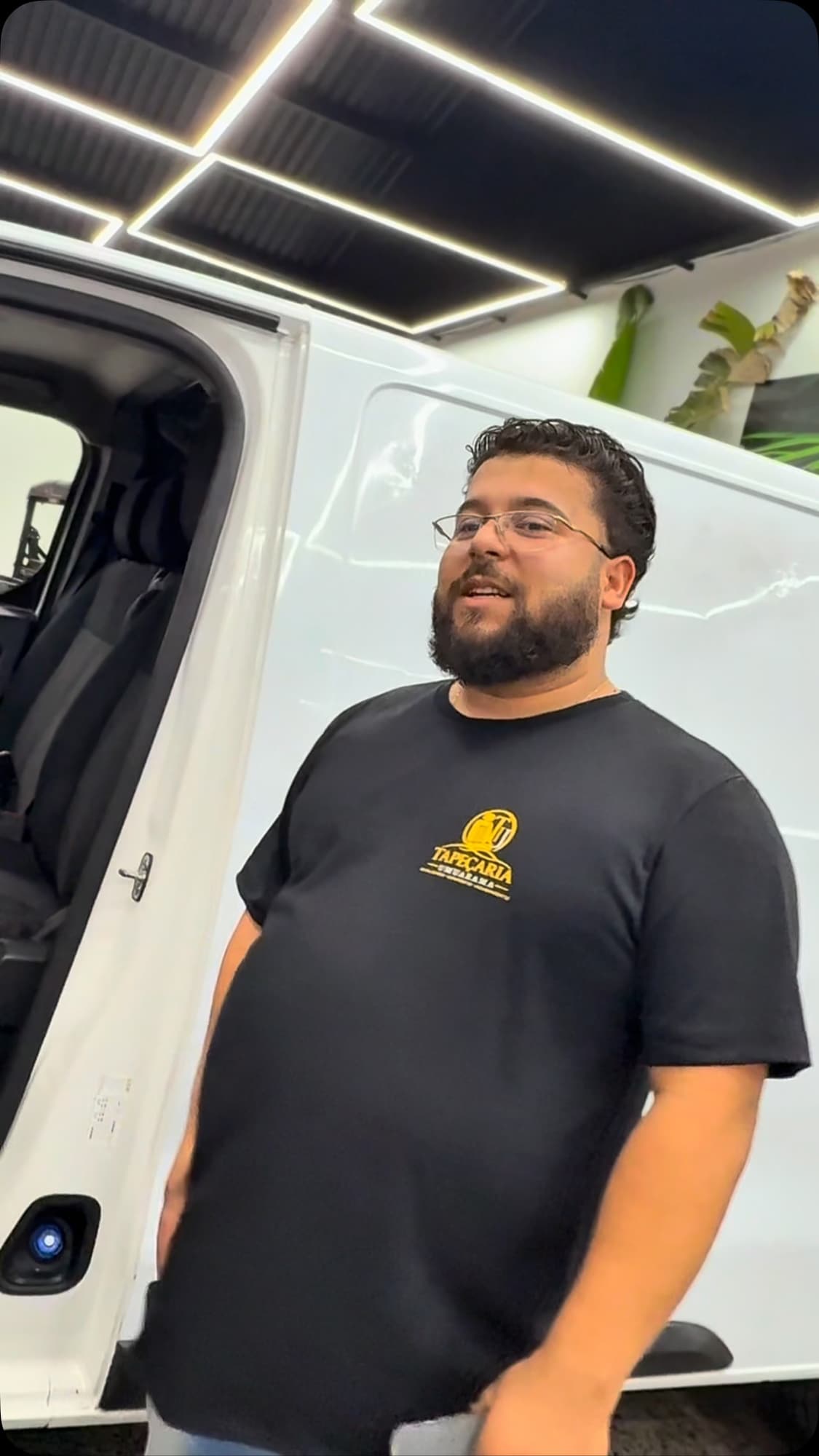 Integrante da equipe usando camiseta preta com o logo da Tapeçaria Umuarama
